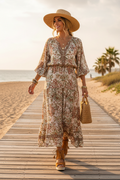 Woman on beach boardwalk in tan suede tassel wedge sandals