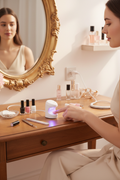 Woman using mini UV nail lamp at vanity